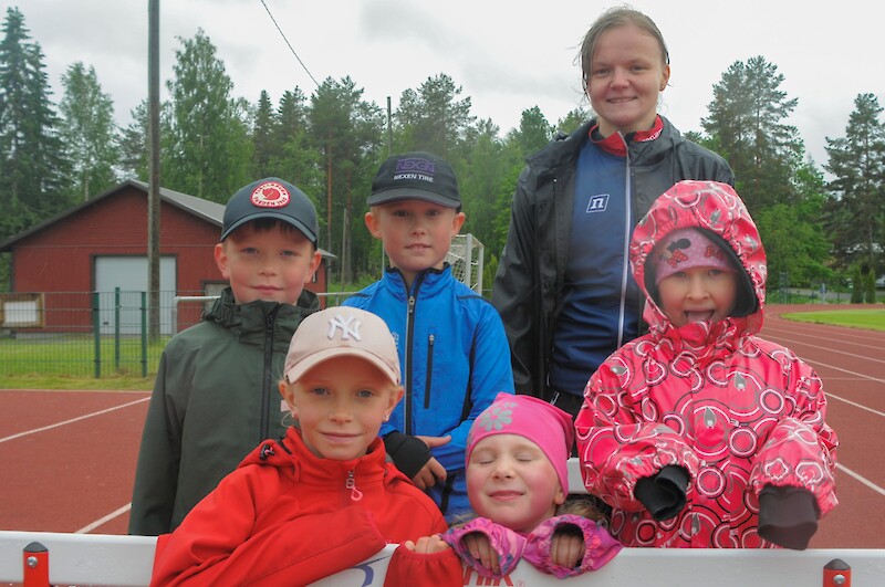 Lapsia ja ohjaaja urheilukentällä